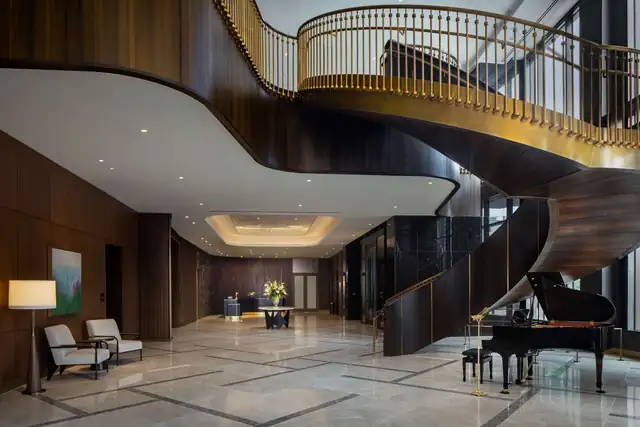 Conrad Nashville in Nashville, spacious lobby with a grand piano and a curved staircase
