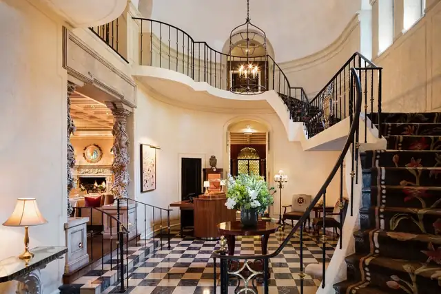 Rosewood Mansion in Dallas, grand lobby with a checkerboard floor, staircase and chandelier