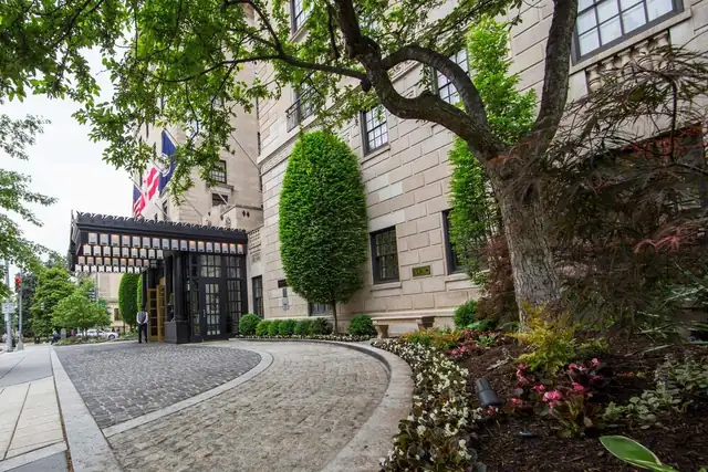 The Jefferson in Washington DC, stone facade with a large tree and a flag