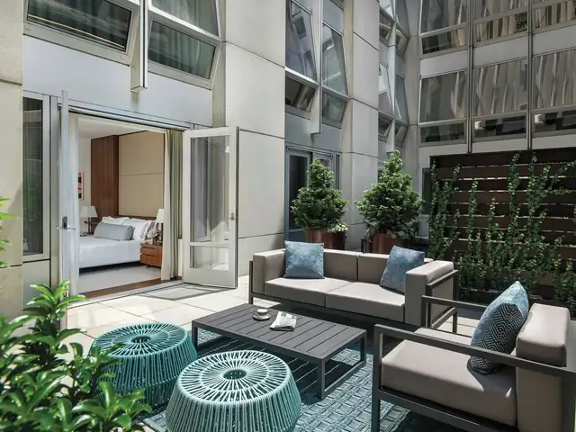 The Langham in New York, modern terrace with a sofa and armchairs